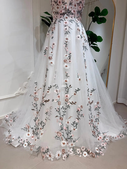 A-line wedding dress in white tulle with delicate 3D pink floral embroidery and botanical vine details.