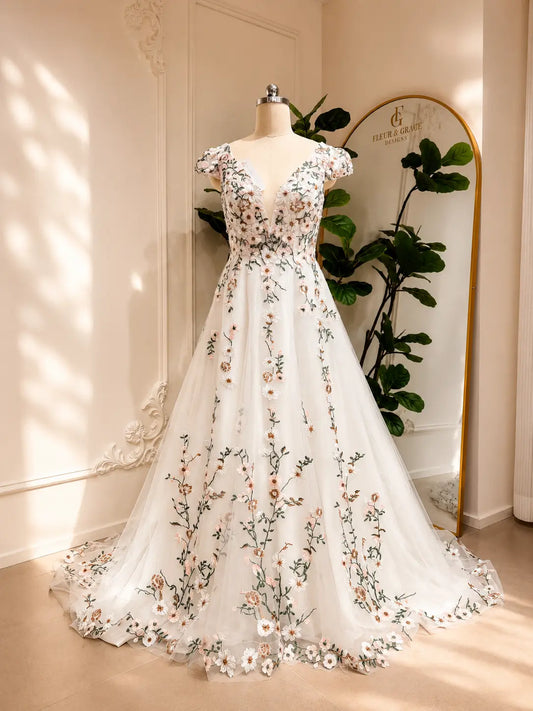 A-line wedding dress with cap sleeves, illusion V-neck, and white tulle featuring 3D floral embroidery and vines.