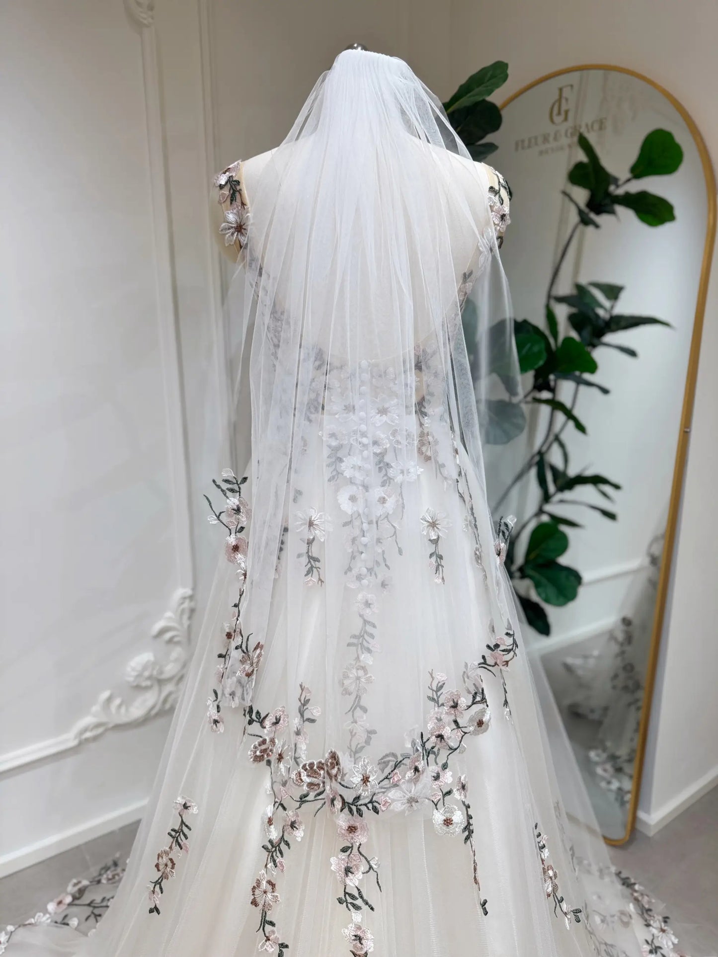 Kate Gown by Fleur&Grace Designs — colorful floral champagne tulle wedding dress with chapel-length train, backless design, zipper closure with covered buttons, side pockets, and optional matching veil.