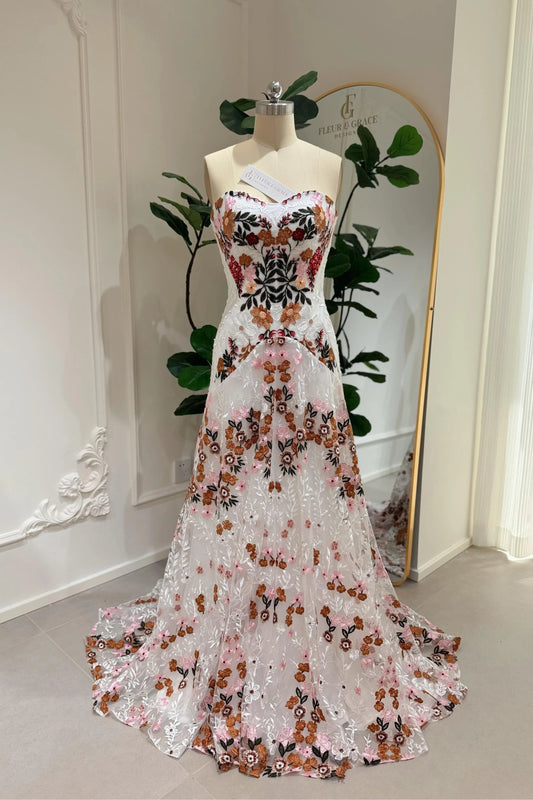 Strapless boho wedding dress with colorful floral guipure lace embroidery on a white sheath silhouette.