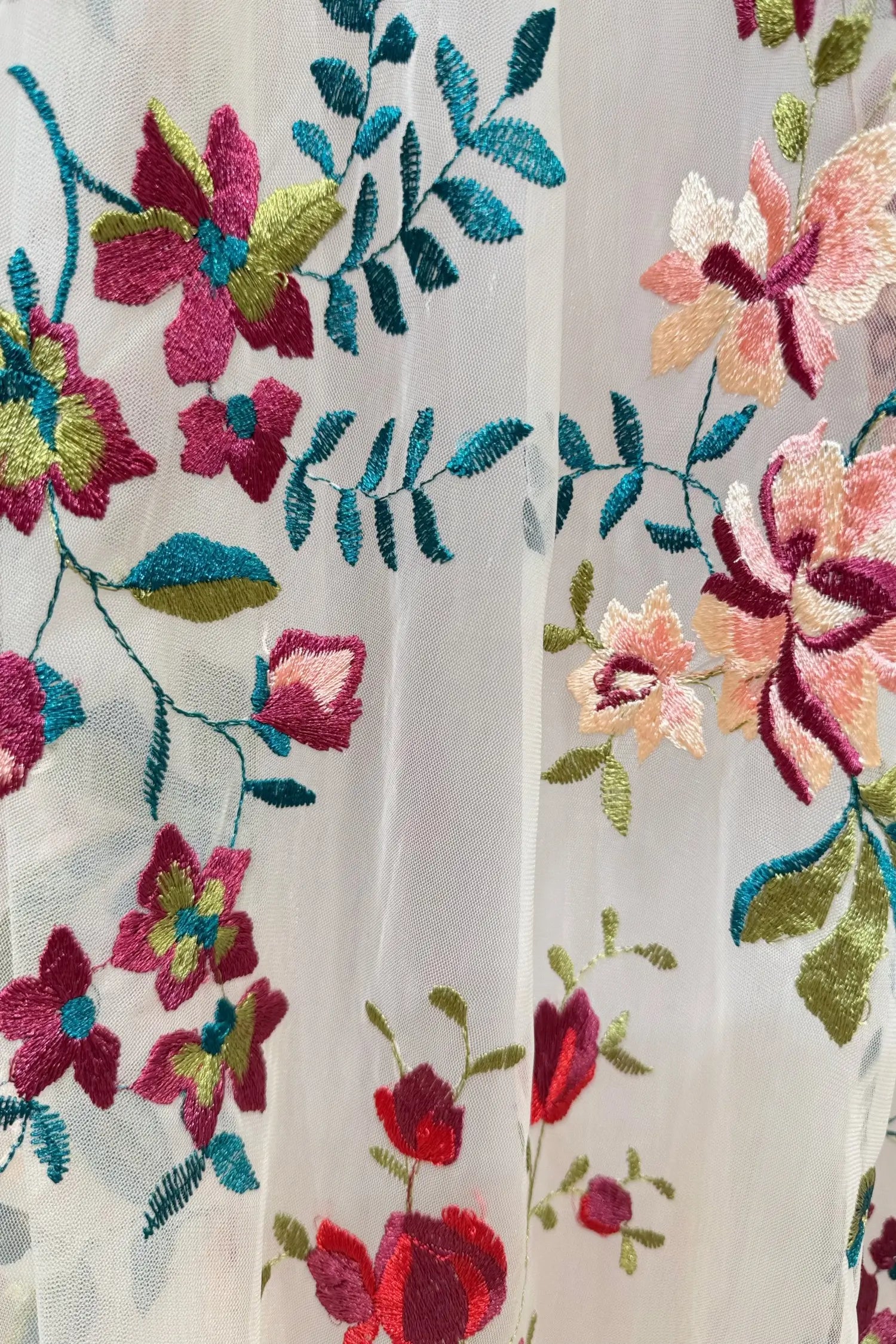 Ferry Gown by Fleur&Grace Designs — whimsical colorful floral wedding dress with pink and burgundy embroidery, long puff sleeves, lace-up back, invisible pockets, and sweep train for forest or elopement weddings.