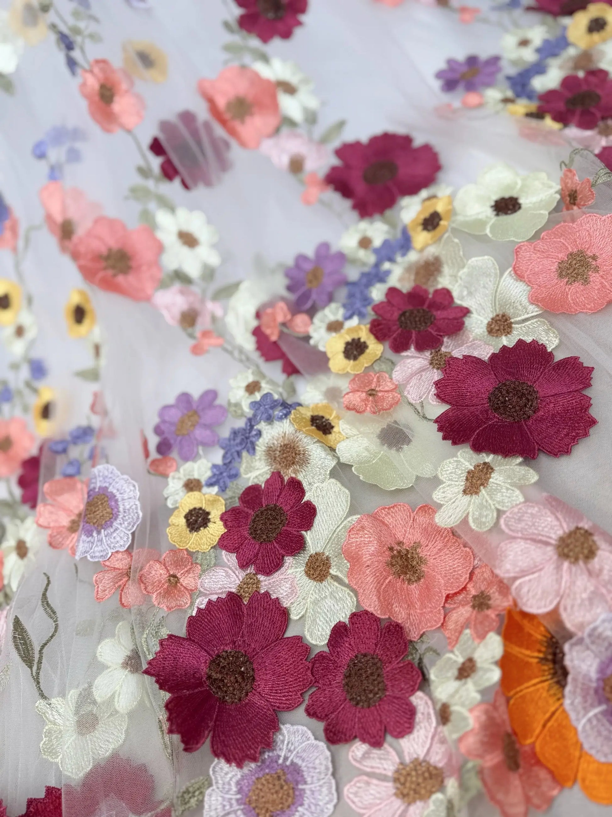 Amber Gown by Fleur&Grace Designs — off-white tulle wedding dress with colorful floral embroidery, off-the-shoulder neckline, plunging V-neck, hidden pockets, and chapel-length train for whimsical and garden weddings.