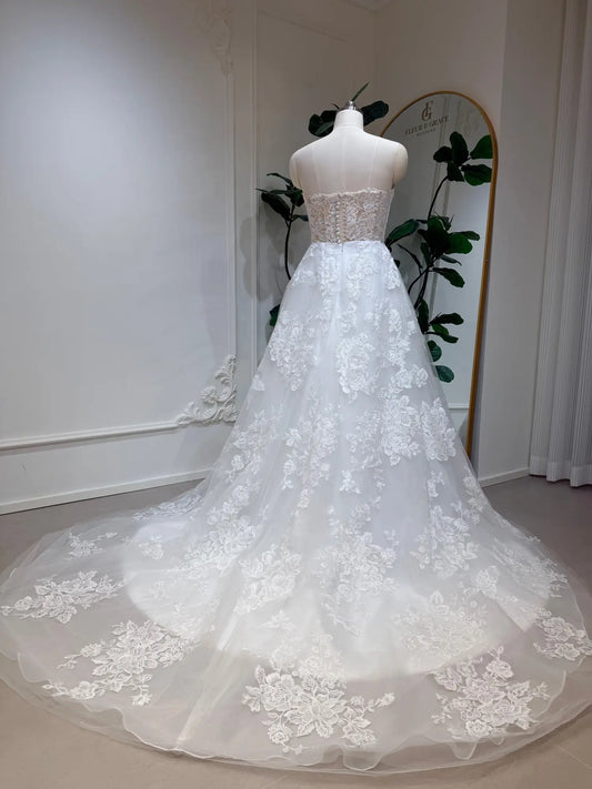 Strapless A-line wedding dress with floral lace appliqués, a fitted bodice, and a flowing tulle chapel train.