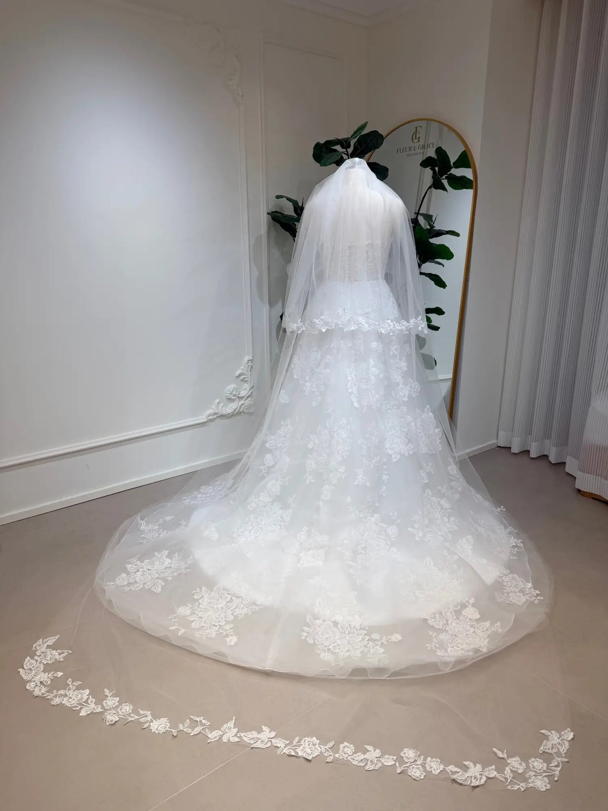 Strapless A-line wedding dress with floral lace appliqués, tulle skirt, chapel train, and matching lace-trimmed veil.