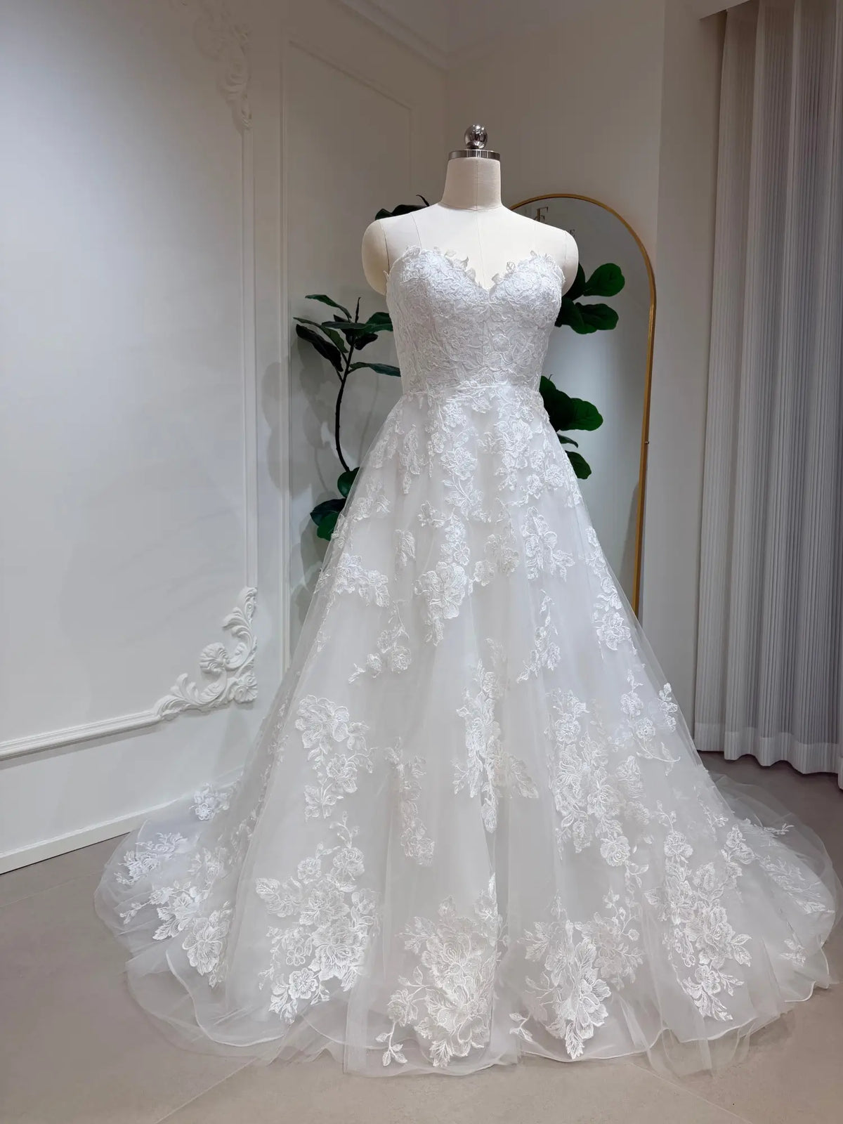 Strapless A-line wedding dress with a sweetheart neckline, beaded floral lace appliqués, and a full tulle skirt.