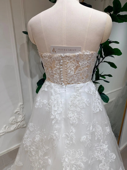 Strapless A-line wedding dress with floral lace bodice, illusion back, and delicate button-down detailing.