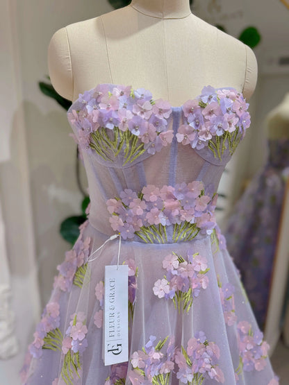 Lavender strapless gown with 3D hydrangea floral lace, sweetheart bodice, and shimmering mesh on a dress form.