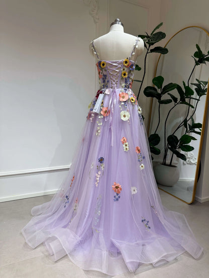 Lavender tulle formal gown with floral embroidery, lace-up back, and sparkly skirt on a mannequin.