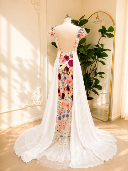 White chiffon A-line wedding dress with an open back and colorful floral embroidered panel cascading down the train.