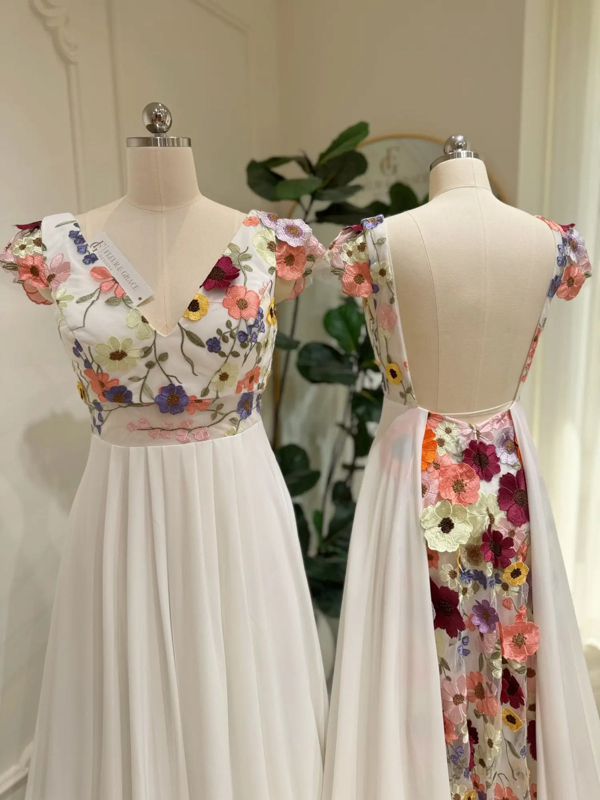 Chiffon A-line wedding dress with vibrant floral embroidered bodice, cap sleeves, and a dramatic open back.