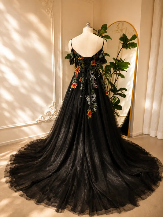Black tulle wedding dress with vibrant floral embroidery, spaghetti straps, off-the-shoulder sleeves, and lace-up corset back.