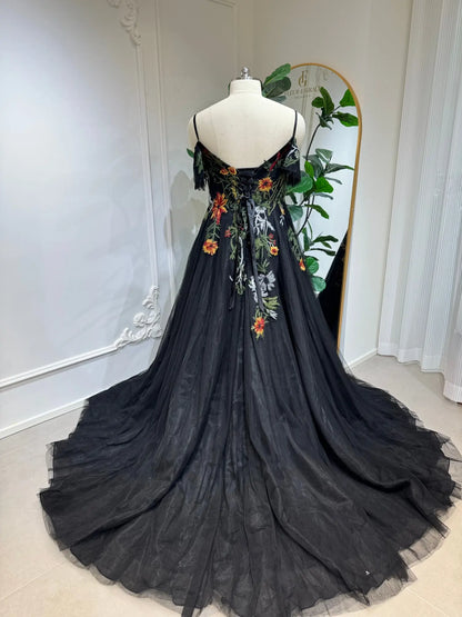 Black tulle wedding dress with vibrant floral embroidery, corset lace-up back, spaghetti straps, and flowing A-line skirt.