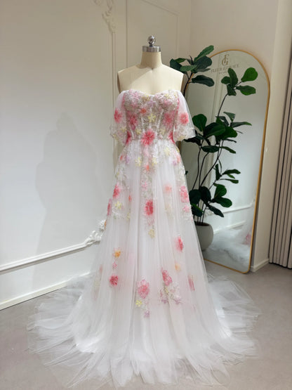 Pink tulle wedding gown with 3D floral appliqués, off-shoulder sleeves, sweetheart neckline, and chapel-length train.