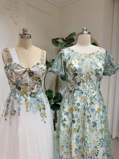 Meadow green tulle wedding gowns with intricate blue and yellow floral embroidery, puff sleeves, and A-line silhouettes.