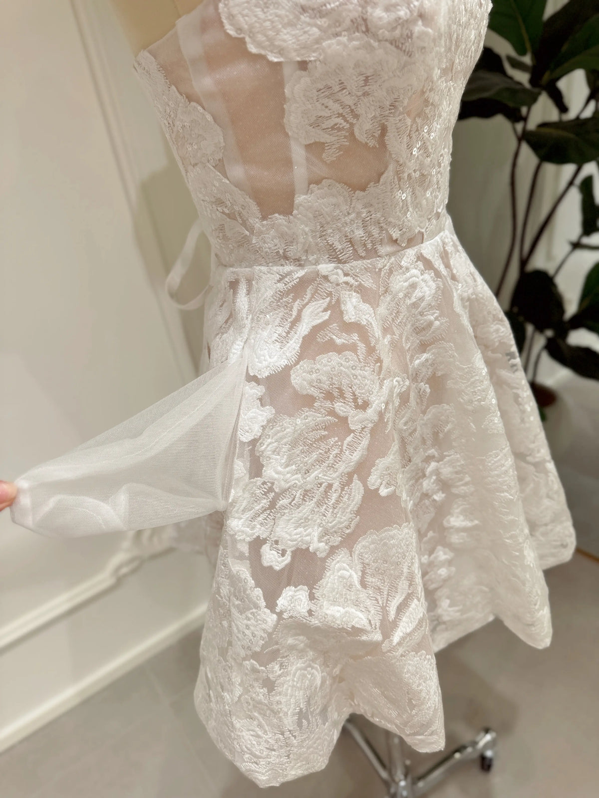 Strapless white floral embroidered mini bridal dress with a corset bodice, sequin details, and a hidden side pocket.
