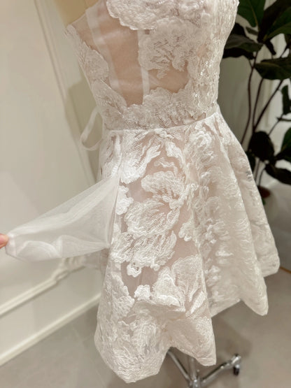 Strapless white floral embroidered mini bridal dress with a corset bodice, sequin details, and a hidden side pocket.