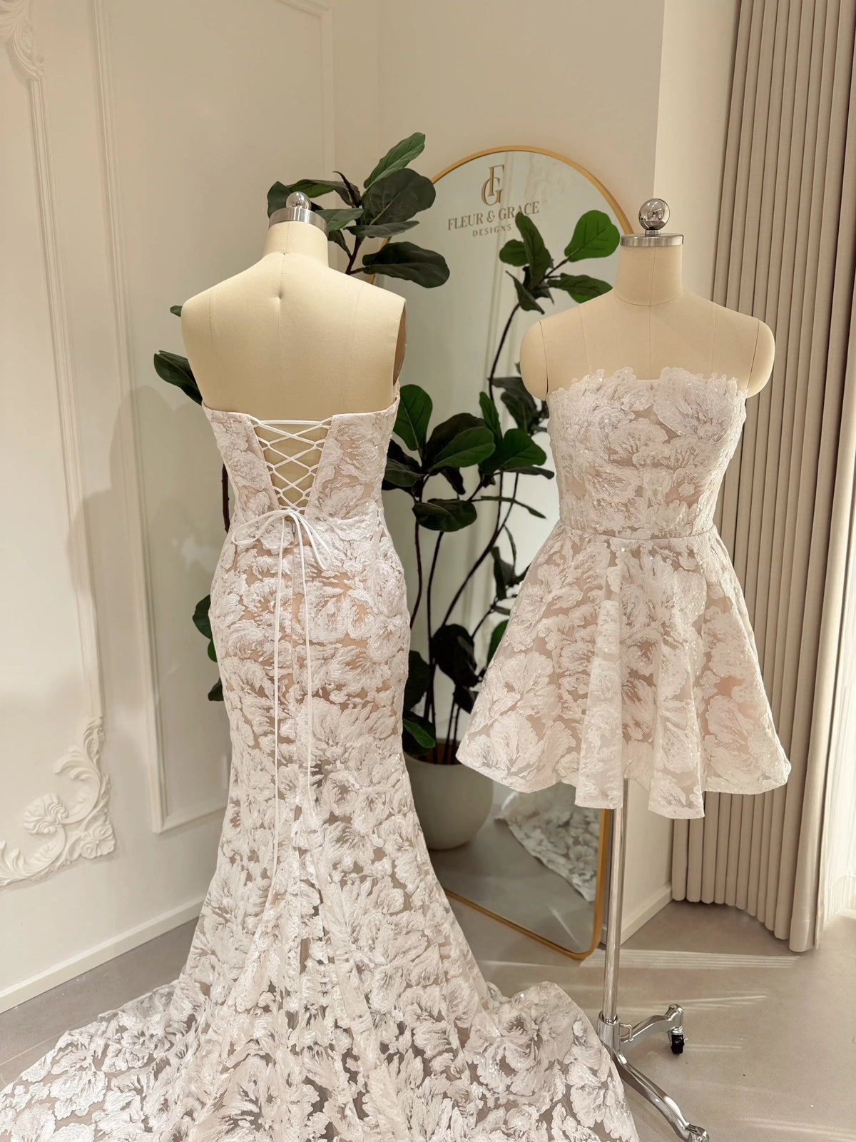 Strapless white floral lace mini dress with corset bodice, lace-up back, and pockets on a mannequin.
