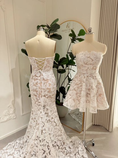 Strapless white floral lace mini dress with corset bodice, lace-up back, and pockets on a mannequin.