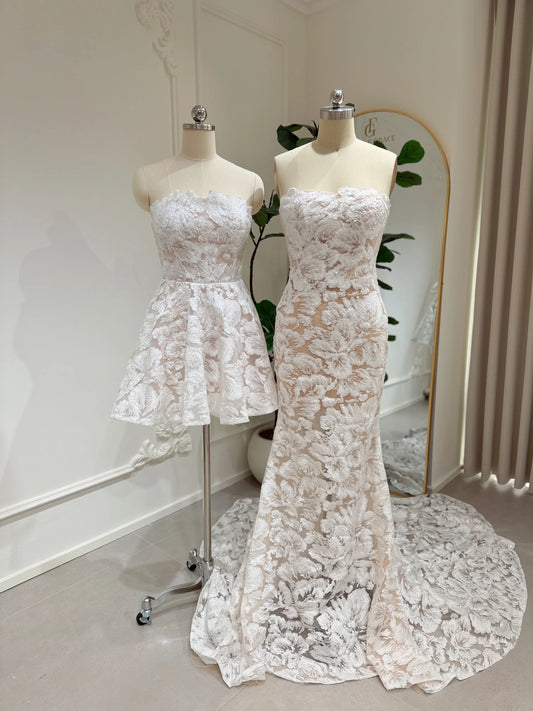 Strapless white floral embroidered lace mini and floor-length bridal dresses on mannequins with corset bodices.