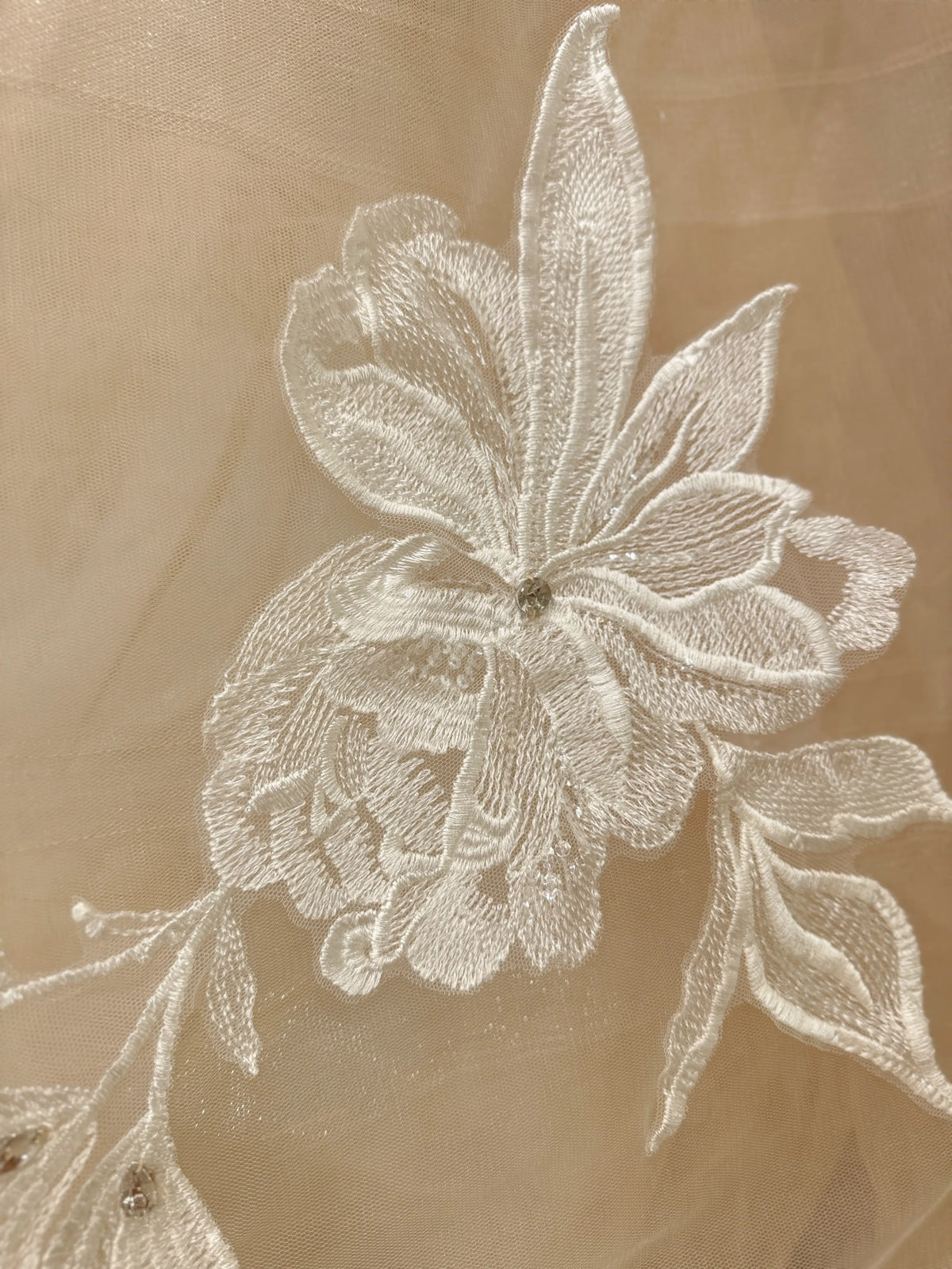 Ivory floral embroidery with rhinestone accents on sheer nude tulle fabric for the Mira wedding gown.