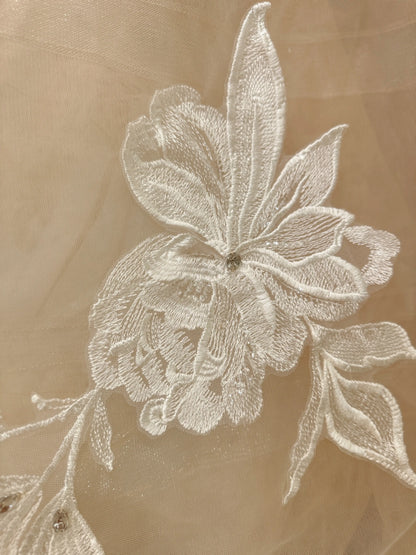 Ivory floral embroidery with rhinestone accents on sheer nude tulle fabric for the Mira wedding gown.