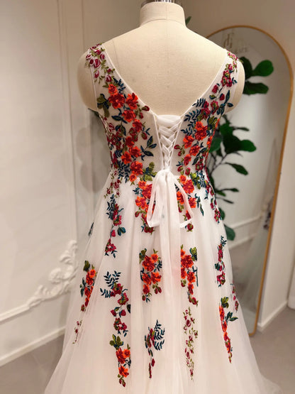 Romantic A-line wedding dress featuring vibrant floral embroidery on white tulle with an elegant lace-up corset back.