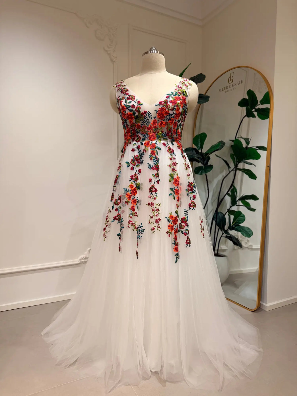 Romantic A-line wedding dress with vibrant floral embroidery on white tulle and a flattering structured bodice.