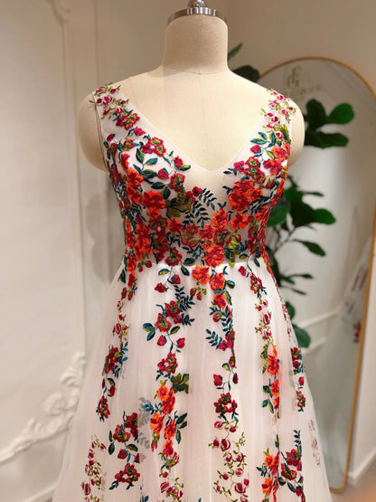 Romantic A-line wedding dress featuring vibrant floral embroidery on soft white tulle with a flattering V-neck bodice.