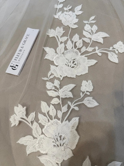 Delicate white floral lace appliqué on soft nude tulle for the Nola mermaid wedding dress.