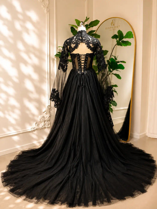 Black gothic wedding dress with lace-up corset back, intricate floral lace, and dramatic detachable sheer sleeves.