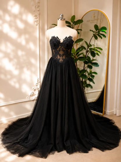 Black gothic wedding dress with a corset bodice, intricate floral lace appliqué, and a voluminous tulle A-line skirt.