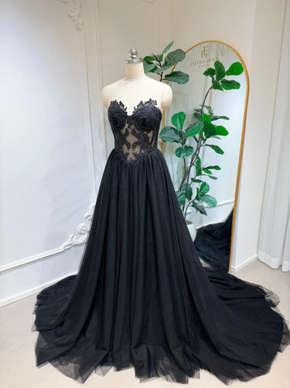 Black gothic wedding dress with a structured lace corset bodice and a voluminous A-line tulle skirt on a mannequin.