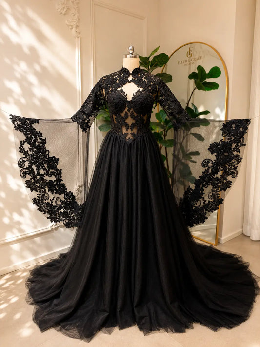 Black gothic wedding dress with intricate lace bodice, corset detailing, and dramatic detachable sheer bell sleeves.