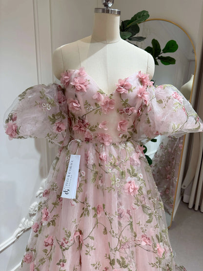 Pink organza prom gown with 3D floral lace, green leaf prints, sweetheart neckline, and removable puffy sleeves.