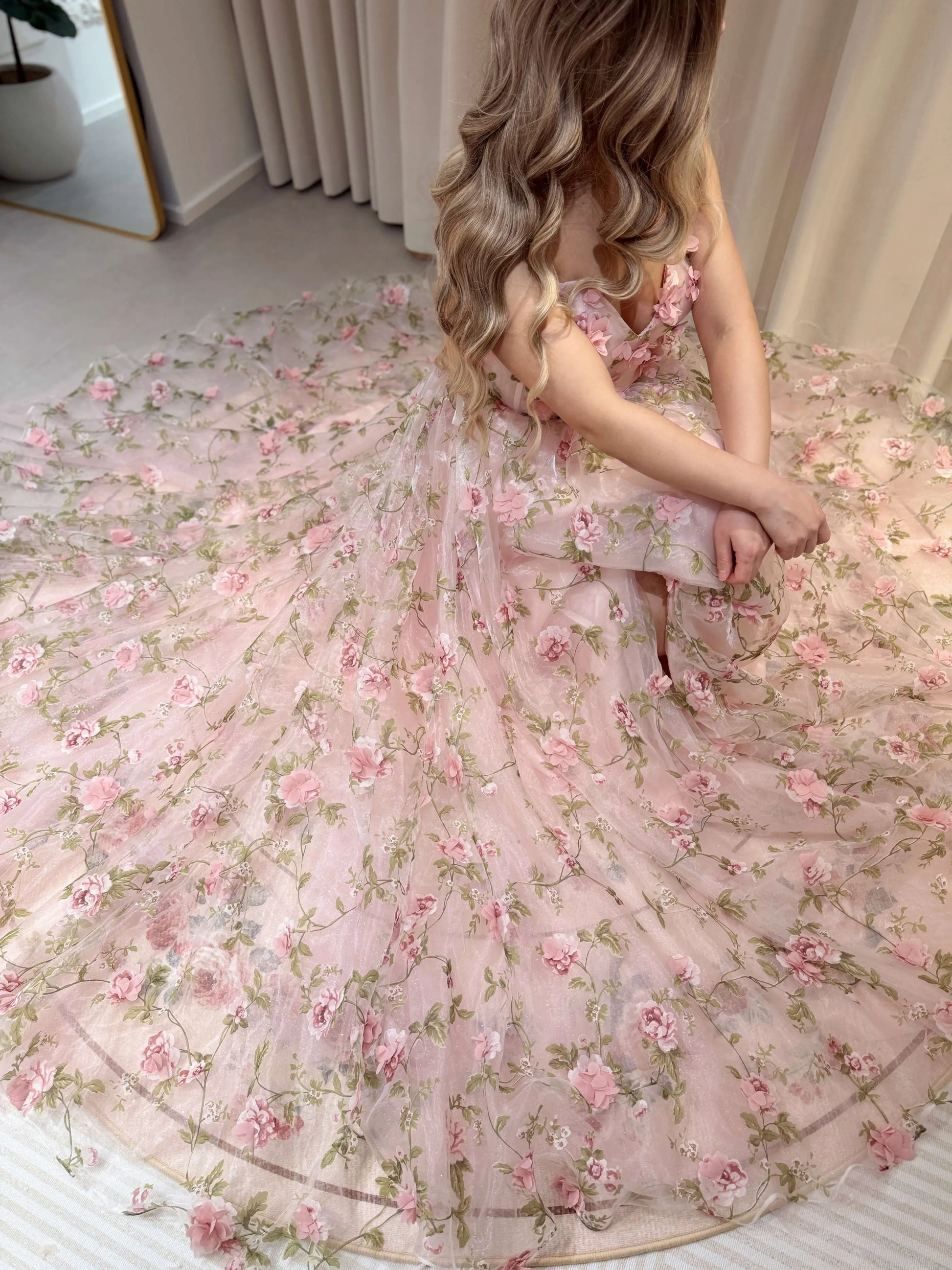 Pink 3D floral organza gown with green leaf prints, sweetheart bodice, and a full, shimmering mesh skirt.