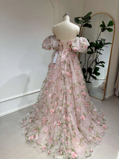 Pink organza gown with 3D floral lace, removable puffy sleeves, and a lace-up back on a dress form.