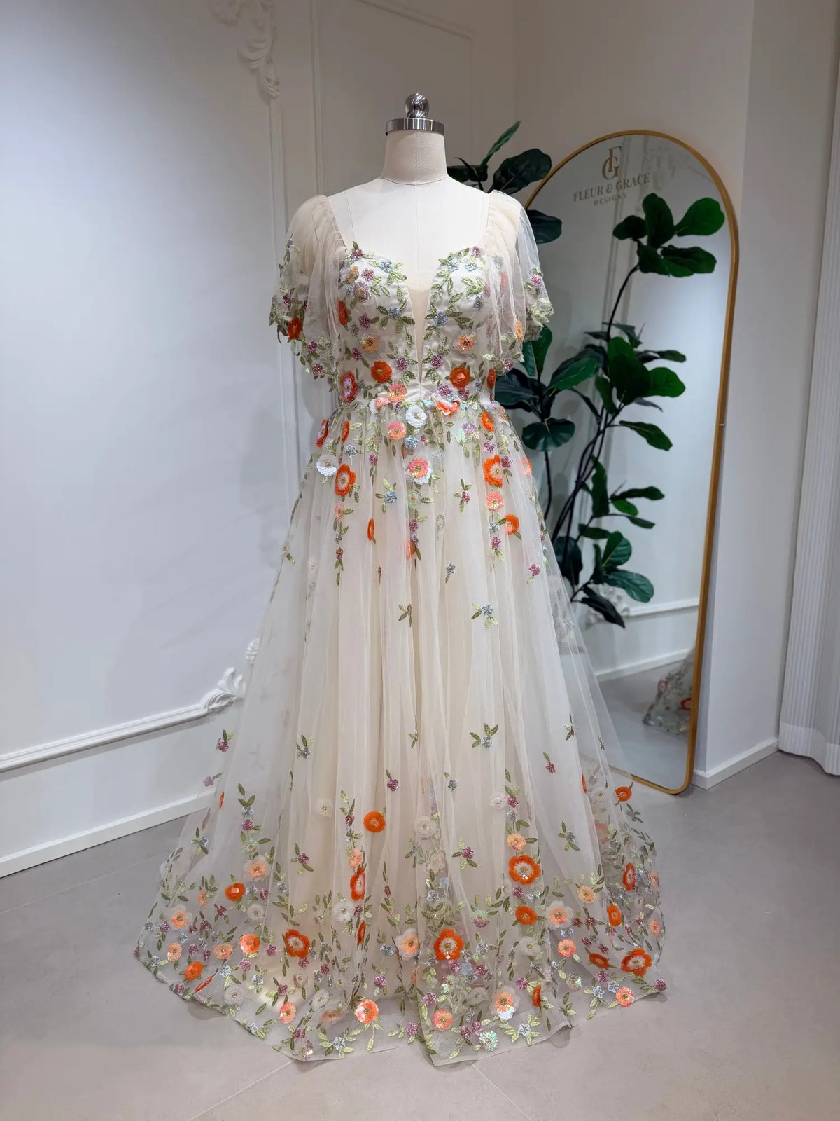 Whimsical A-line wedding dress with multicolor floral embroidery, sheer tulle, and romantic angel sleeves.