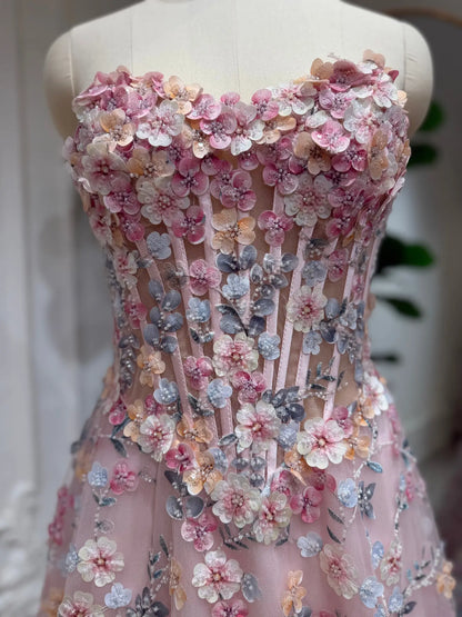 Blush pink tulle prom dress featuring a structured corset bodice with intricate 3D floral embroidery and beaded details.