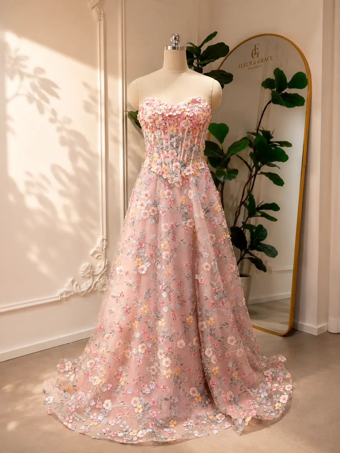 Blush pink tulle prom dress featuring a strapless corset bodice and intricate floral embroidery in an A-line silhouette.