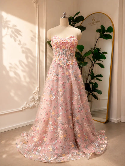 Blush pink tulle prom dress featuring a strapless corset bodice and intricate floral embroidery in an A-line silhouette.