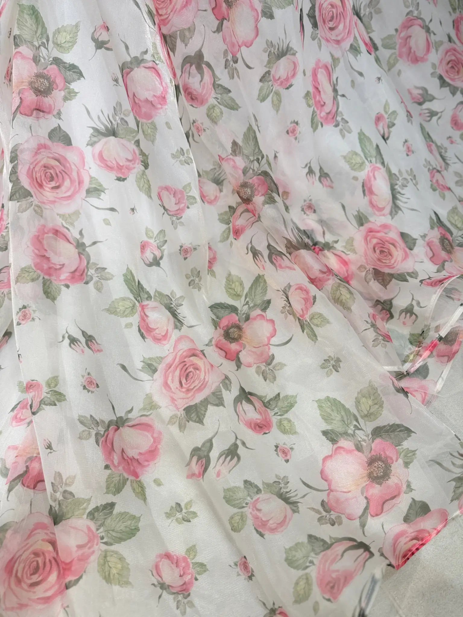 off‑the‑shoulder pink floral printed organza dress with tiered ruffle neckline, functional pockets, and flowing A‑line skirt, ideal for wedding photography and fairy‑tale events.-Model wearing the Rosie Gown FG026 by Fleur&Grace Designs 