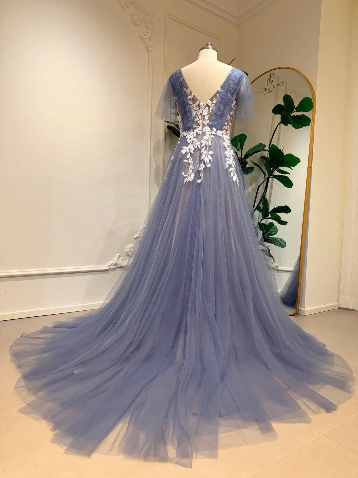 Dusty blue A-line wedding dress featuring a V-neck, flutter sleeves, and intricate white floral lace on flowing tulle.
