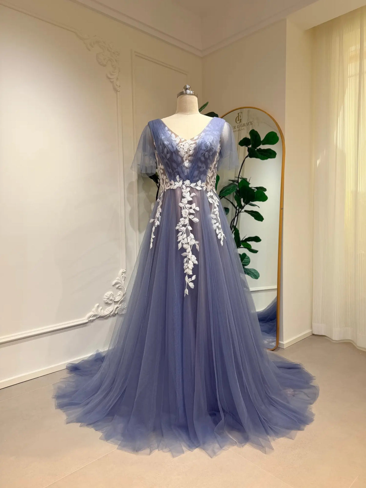 Dusty blue A-line wedding dress with off-white floral lace, V-neck illusion bodice, and romantic flutter sleeves.