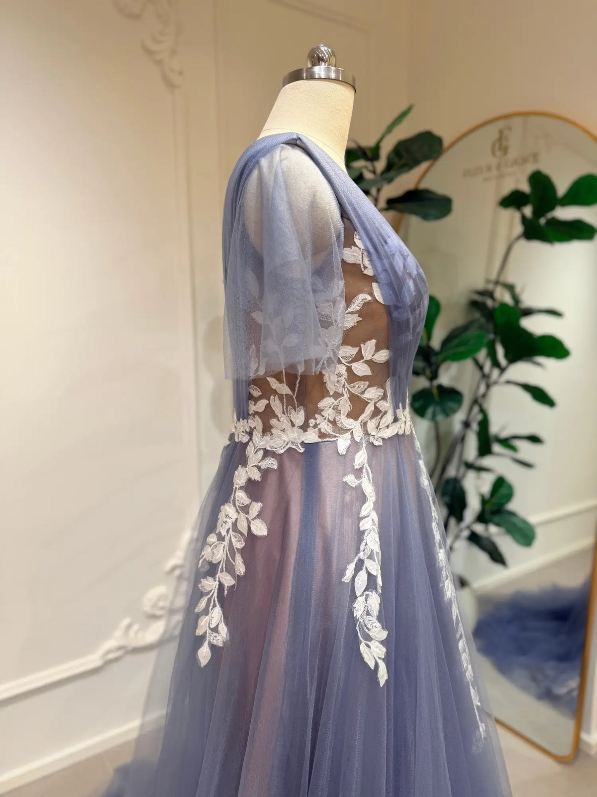 Dusty blue A-line wedding dress featuring delicate off-white floral lace, illusion bodice, and romantic flutter sleeves.