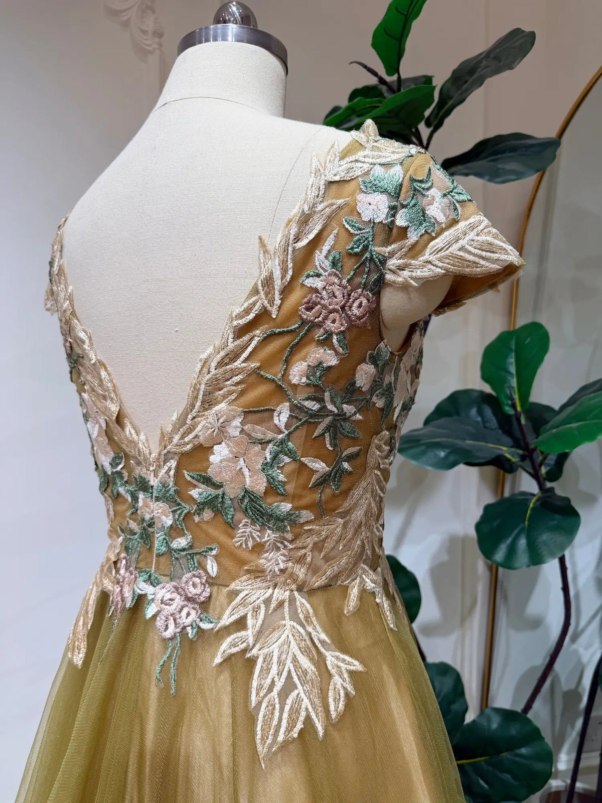 Olive green tulle wedding dress featuring an illusion V-neck bodice with intricate botanical floral embroidery.
