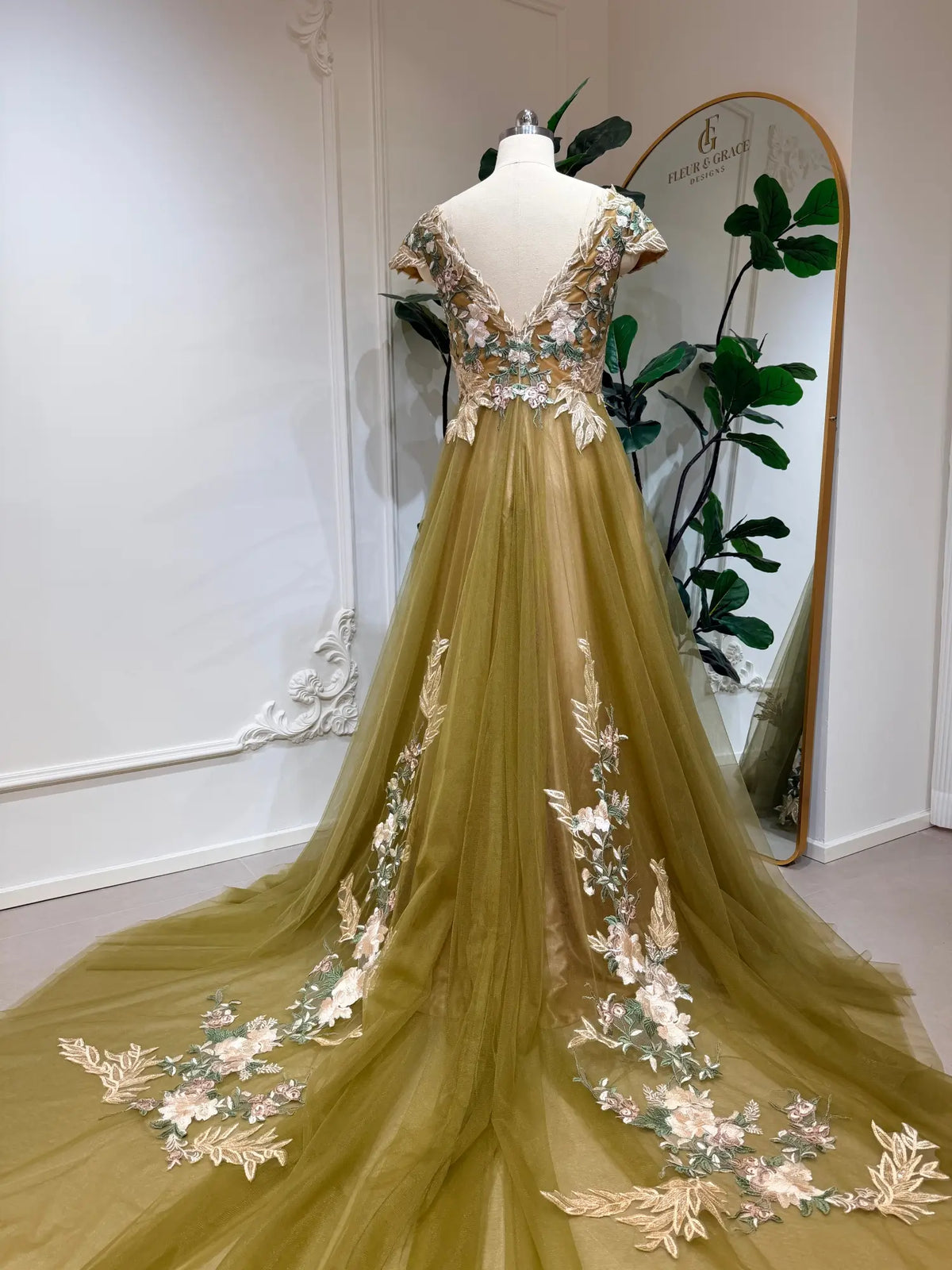 Olive green tulle wedding dress with floral embroidery, V-neck bodice, short sleeves, and a long chapel train.
