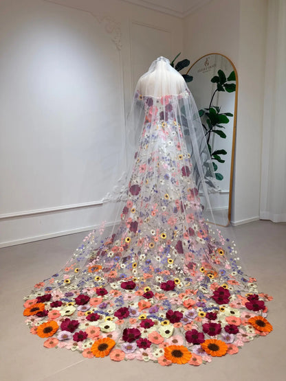 Ivory A-line wedding dress with vibrant floral embroidery, off-shoulder sleeves, and a dramatic wildflower-inspired train.