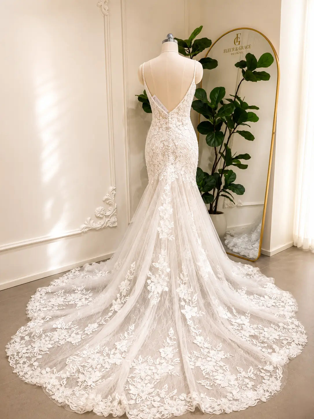 Ivory mermaid wedding dress with floral lace appliqués, low V-back, and a dramatic chapel-length tulle train.