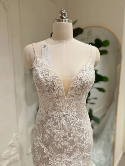 Ivory mermaid wedding dress featuring intricate floral lace appliqués, a deep V-neckline, and a flattering nude illusion bodice.