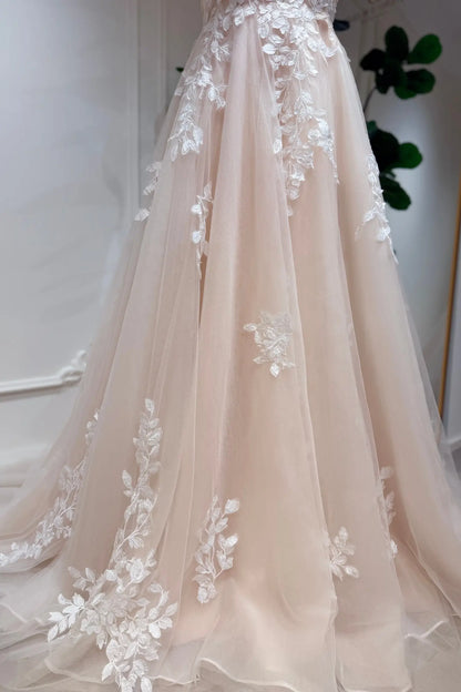 Champagne A-line wedding dress in airy tulle with delicate white floral lace appliqué cascading down the skirt.